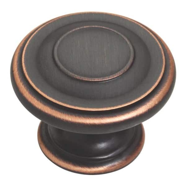 Bouton de meuble rond en bronze huilé avec détails circulaires.
