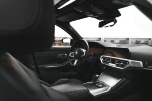 Habitacle automobile moderne avec volant, écran central et sièges sombres