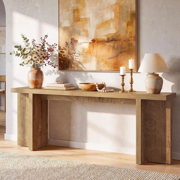 Console en bois épurée avec lampe, tableau abstrait et vase fleuri